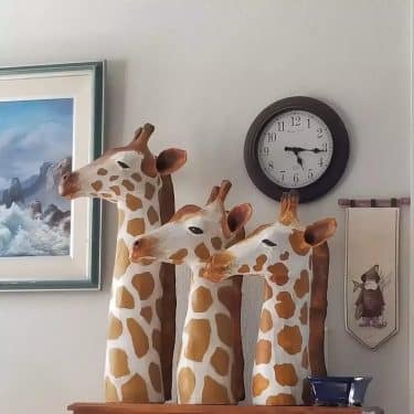 Three giraffe head sculptures